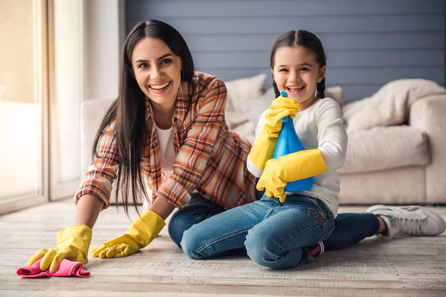 zena sa detetom sedi napodusa krpom u ruci za ciscenje tepiha